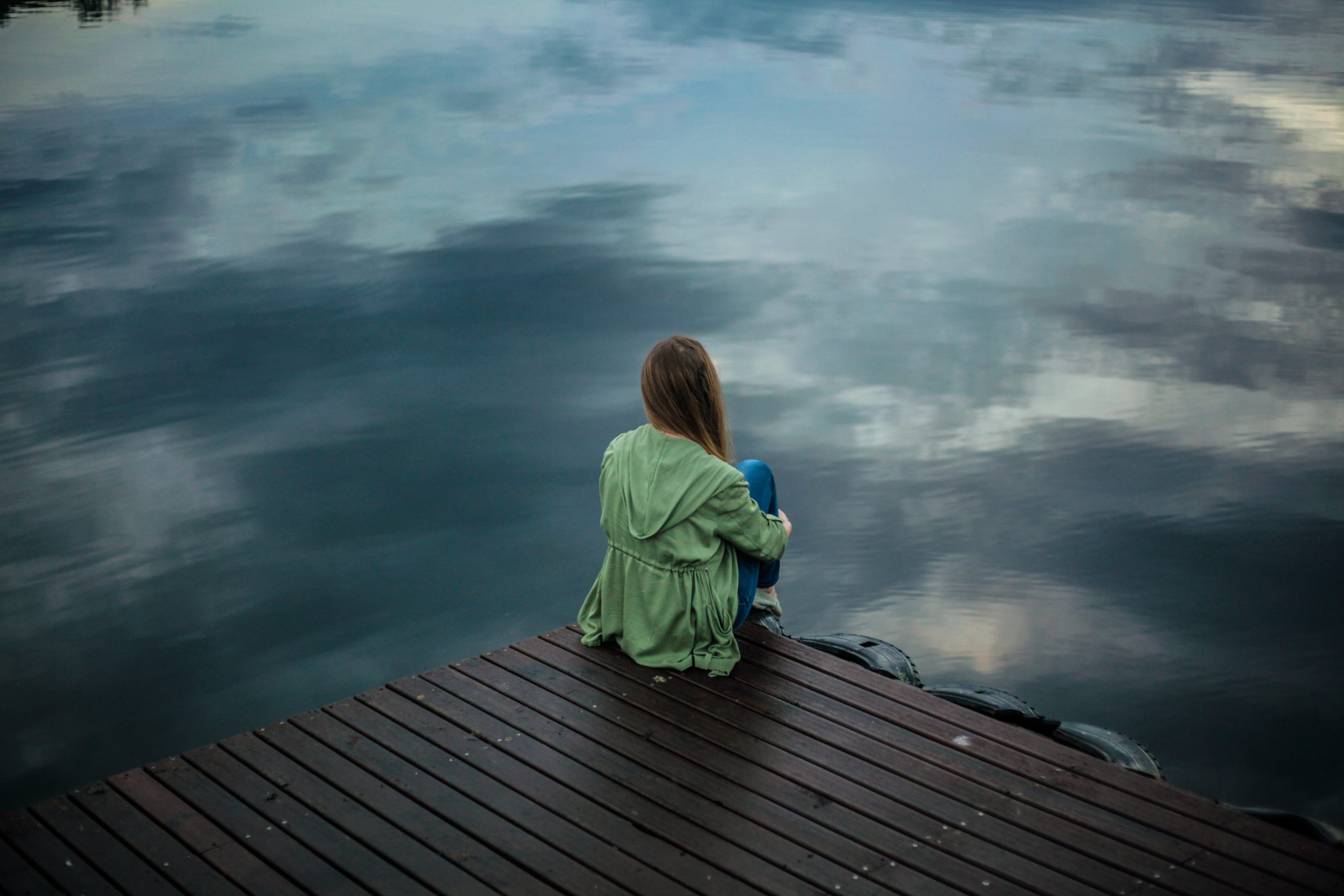 woman sitting on edge of dock